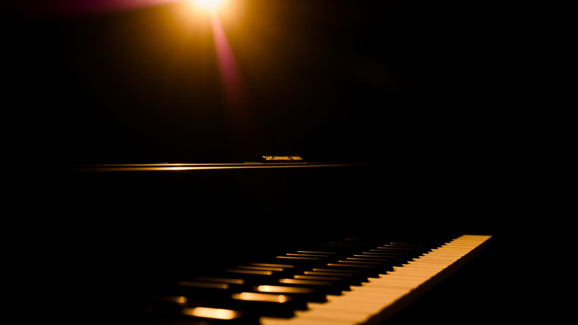 Grand piano under warm stage light